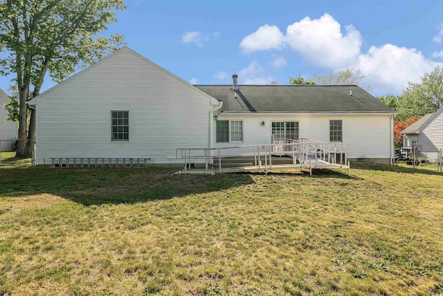 back of property with a lawn, fence, and a wooden deck