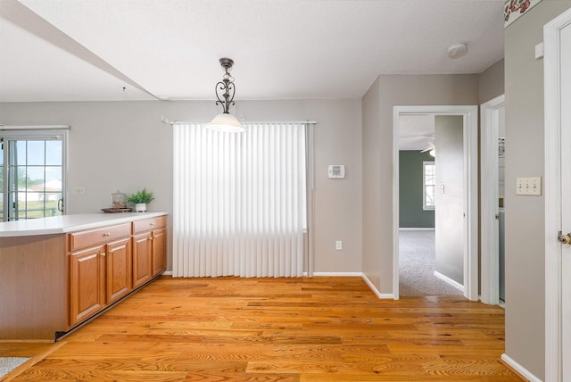 unfurnished dining area featuring baseboards and light wood-style flooring