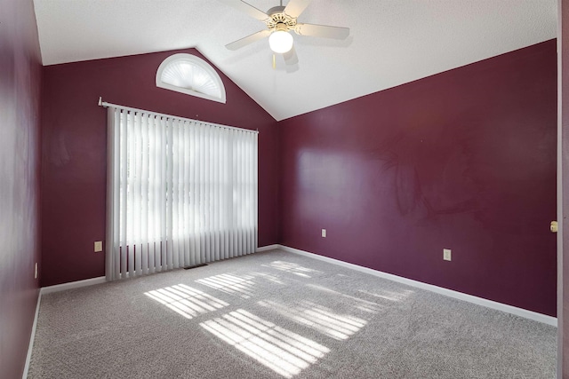 carpeted empty room with baseboards, a ceiling fan, and lofted ceiling
