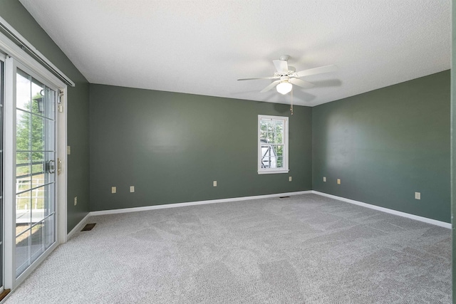 spare room featuring baseboards, a ceiling fan, carpet flooring, and visible vents