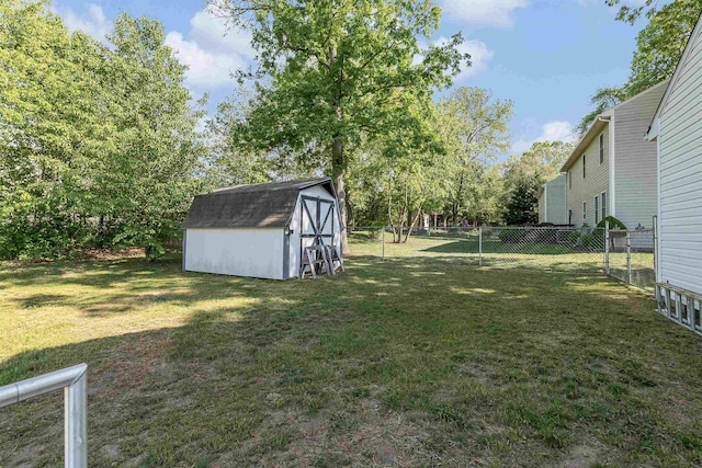 view of yard featuring a fenced backyard, a storage unit, and an outbuilding