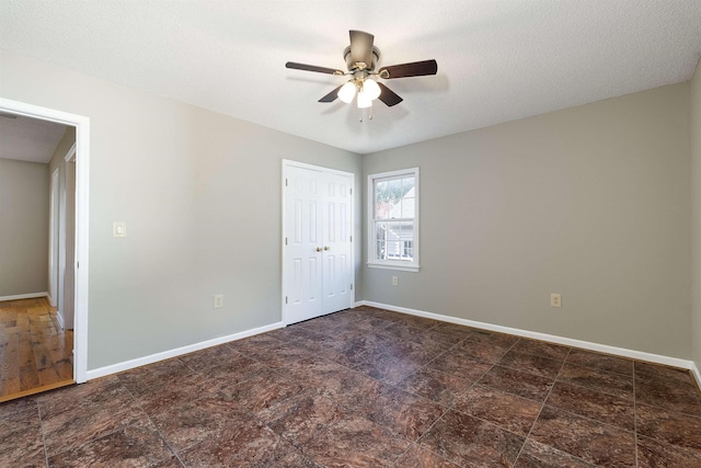 unfurnished room with baseboards and a ceiling fan