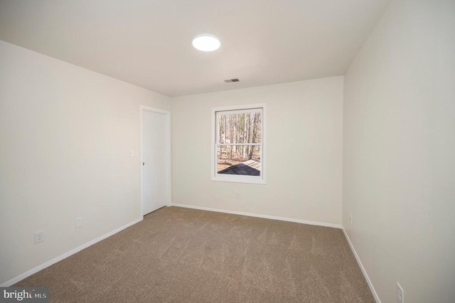 spare room featuring visible vents, baseboards, and carpet