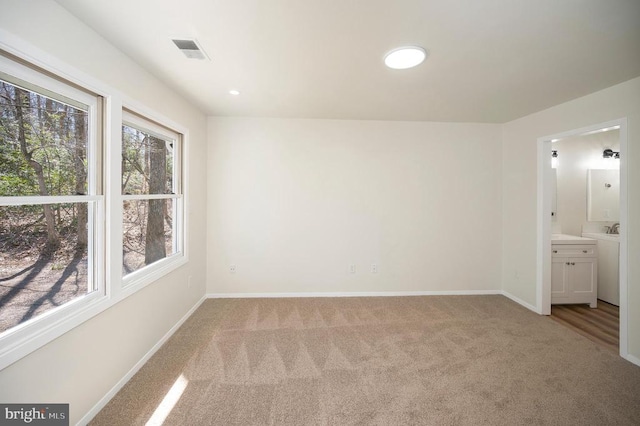 unfurnished room featuring visible vents, baseboards, and light colored carpet