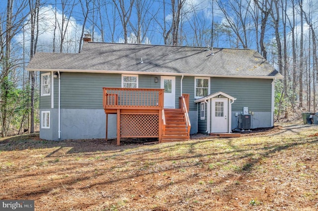 back of property with a shingled roof, a wooden deck, stairs, central AC, and a chimney