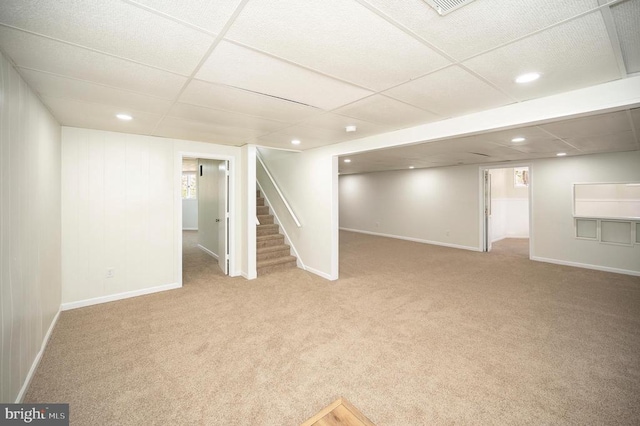 finished basement featuring recessed lighting, stairway, baseboards, carpet, and a paneled ceiling