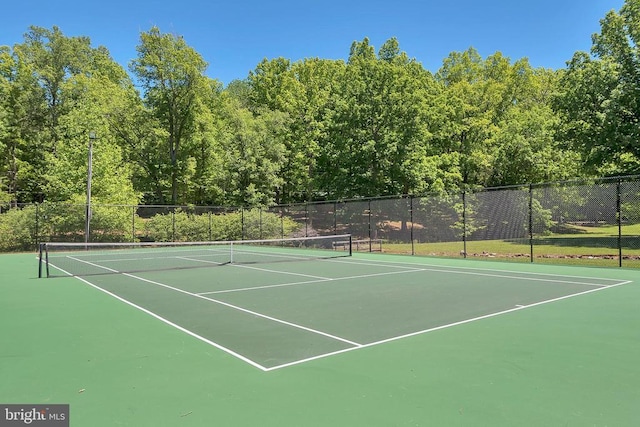 view of tennis court featuring fence