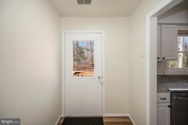 doorway featuring wood finished floors and baseboards