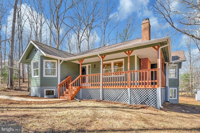 ranch-style home featuring a porch and a chimney