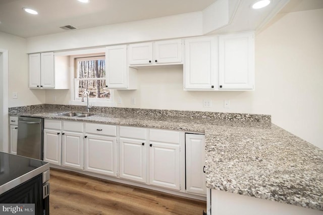 kitchen with white cabinets, dishwasher, and a sink