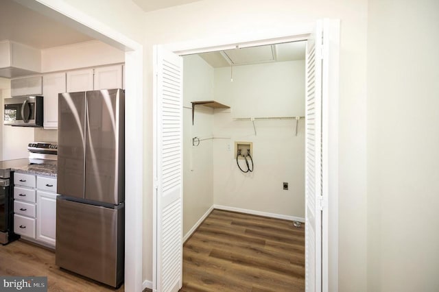 washroom featuring hookup for a washing machine, attic access, wood finished floors, and baseboards