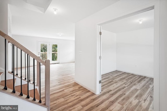 hall with stairway, baseboards, and wood finished floors