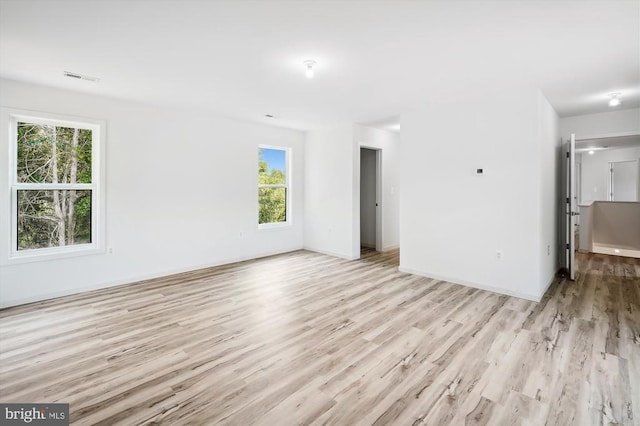 spare room featuring baseboards, visible vents, and light wood finished floors