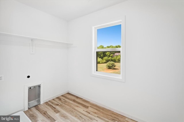 washroom featuring light wood-style floors, baseboards, hookup for an electric dryer, and laundry area