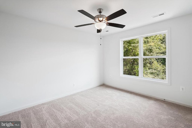 carpeted empty room featuring visible vents, baseboards, and ceiling fan