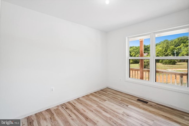 unfurnished room with visible vents, baseboards, and wood finished floors