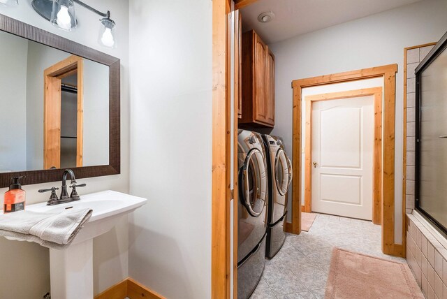 laundry area with separate washer and dryer, sink, and cabinets