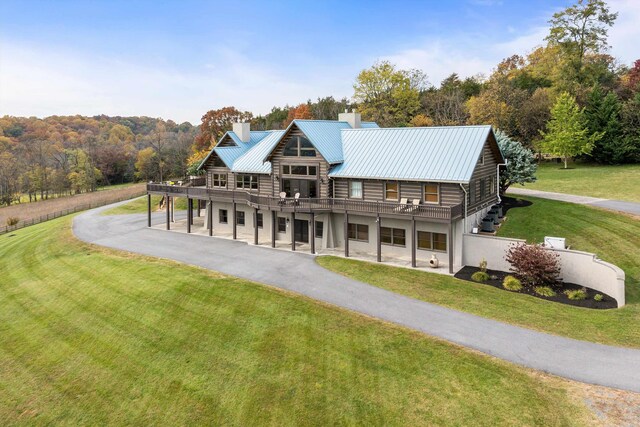 log-style house featuring a wooden deck and a front lawn