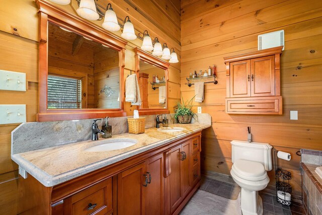 bathroom with a tub to relax in, vanity, toilet, and wood walls