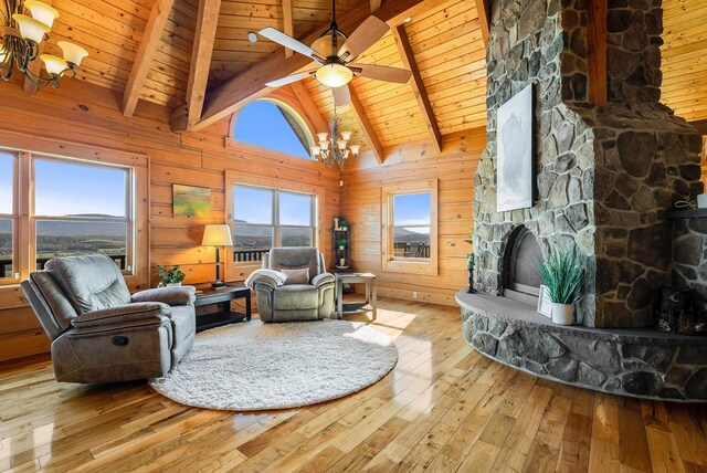 living room featuring wooden ceiling, wooden walls, a stone fireplace, and light wood-type flooring