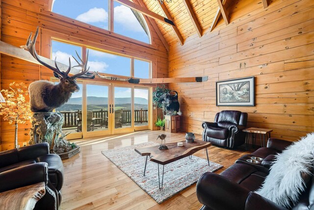 living room with a mountain view, wooden ceiling, beam ceiling, and light hardwood / wood-style floors