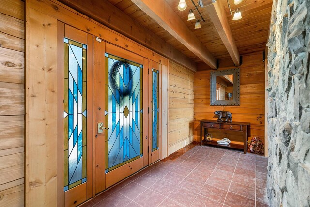 doorway featuring tile patterned flooring, wood ceiling, wooden walls, and beamed ceiling