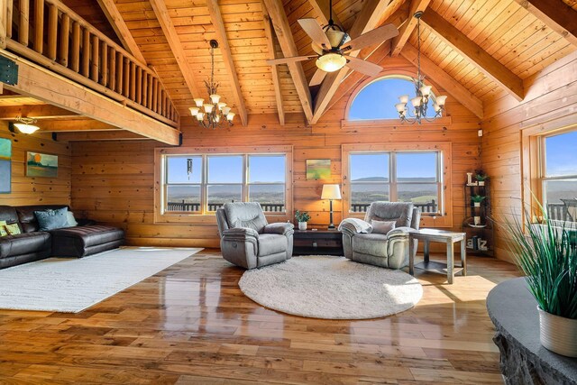 living room with beamed ceiling, wooden ceiling, hardwood / wood-style floors, and wood walls