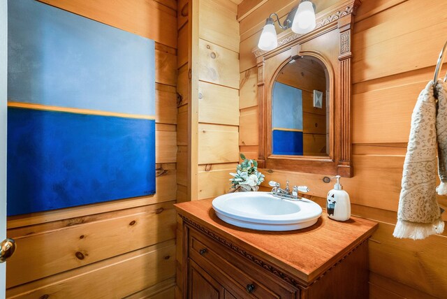 bathroom with vanity and wood walls