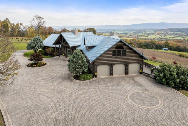 log-style house with a garage and a mountain view