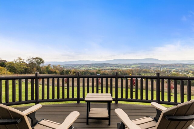 wooden terrace featuring a mountain view and a yard