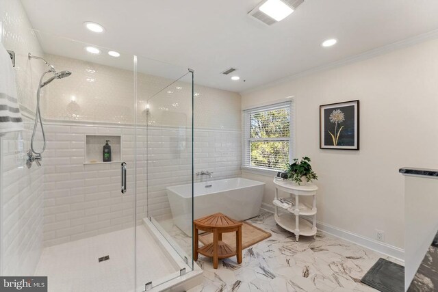 bathroom with baseboards, ornamental molding, marble finish floor, a freestanding tub, and a shower stall