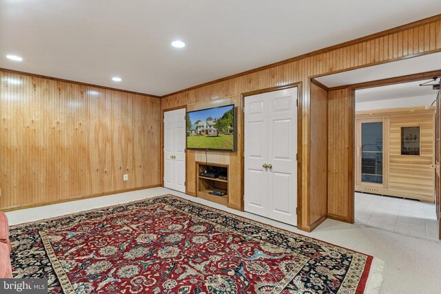 living area with wood walls, baseboards, crown molding, and recessed lighting