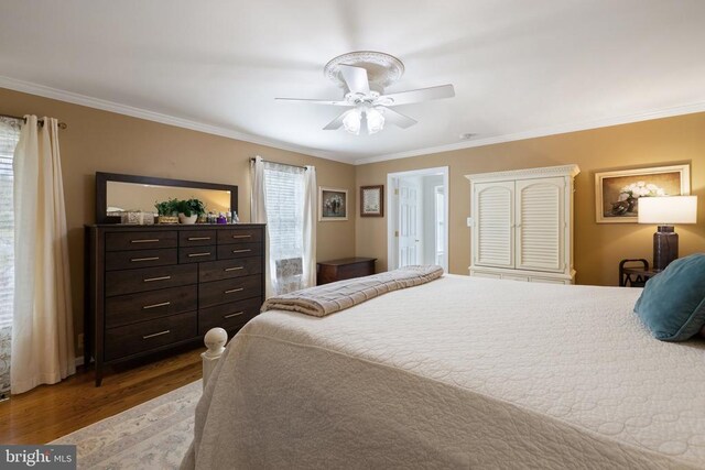 bedroom with ceiling fan, ornamental molding, and dark wood-type flooring