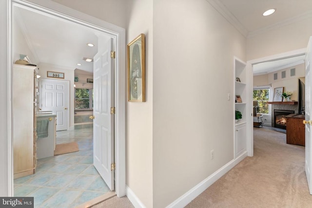 hallway with baseboards, ornamental molding, recessed lighting, and light colored carpet