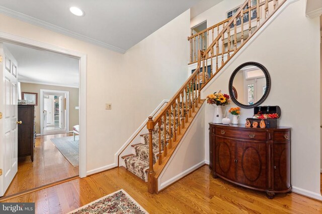 stairway featuring ornamental molding, recessed lighting, baseboards, and wood finished floors