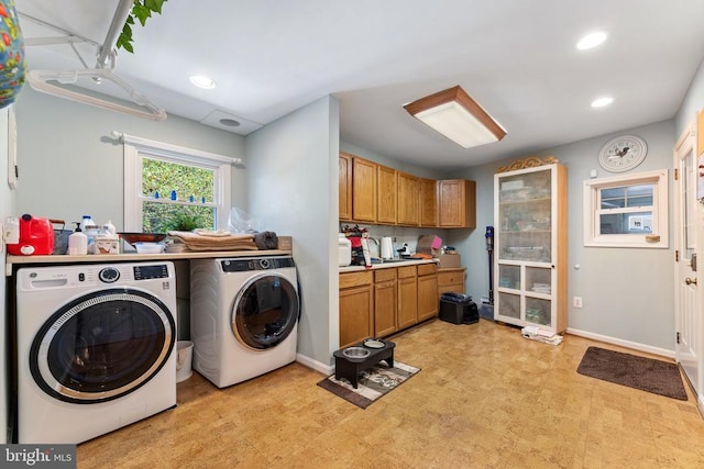 laundry area featuring recessed lighting, laundry area, baseboards, washer and dryer, and light floors