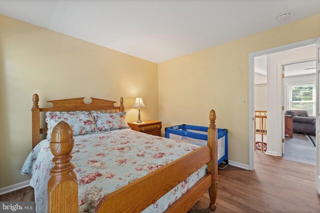 bedroom featuring baseboards and wood finished floors