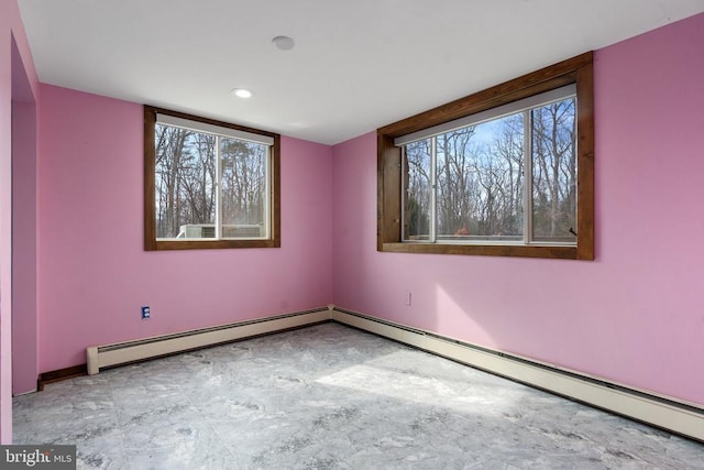 empty room featuring a healthy amount of sunlight and baseboard heating