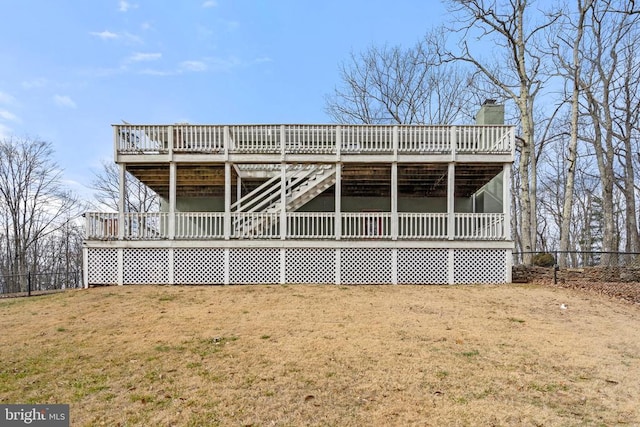 back of property featuring a wooden deck and a yard