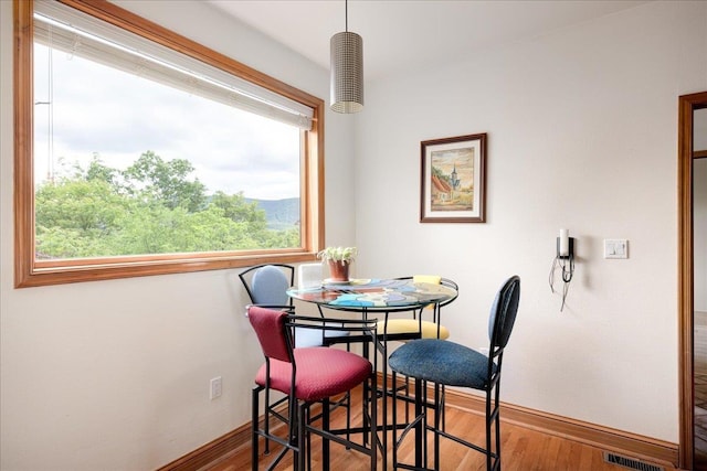 dining space with wood-type flooring