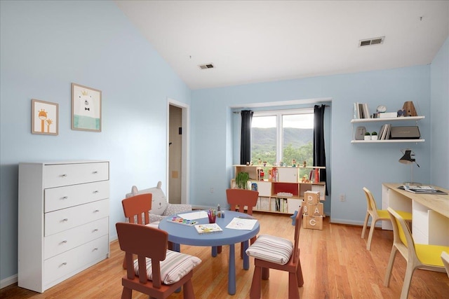 dining room featuring vaulted ceiling and light hardwood / wood-style floors