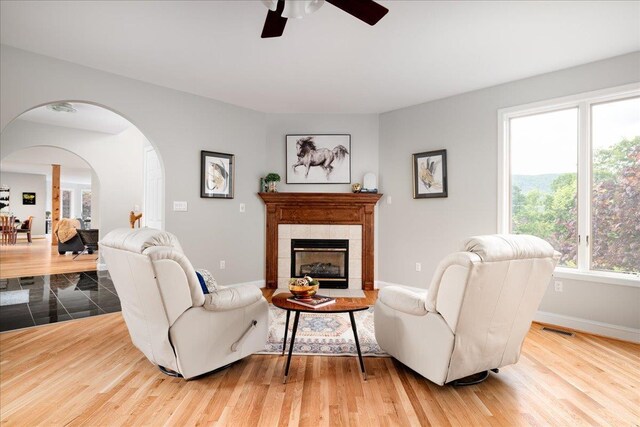 living room featuring a tiled fireplace and light wood-type flooring