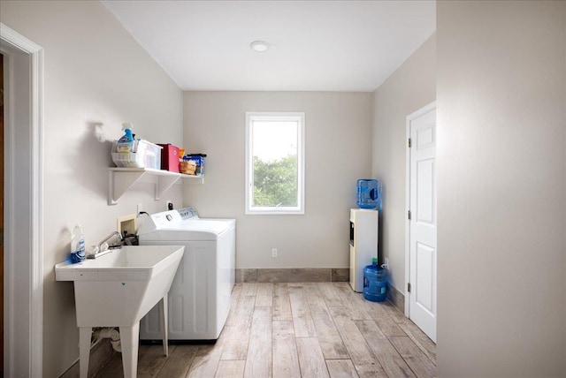 clothes washing area featuring separate washer and dryer and light hardwood / wood-style floors