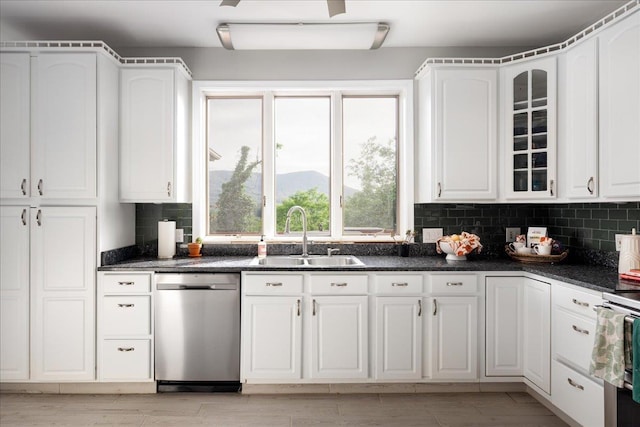 kitchen featuring tasteful backsplash, white cabinetry, appliances with stainless steel finishes, and sink