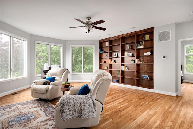 living room with ceiling fan and light wood-type flooring