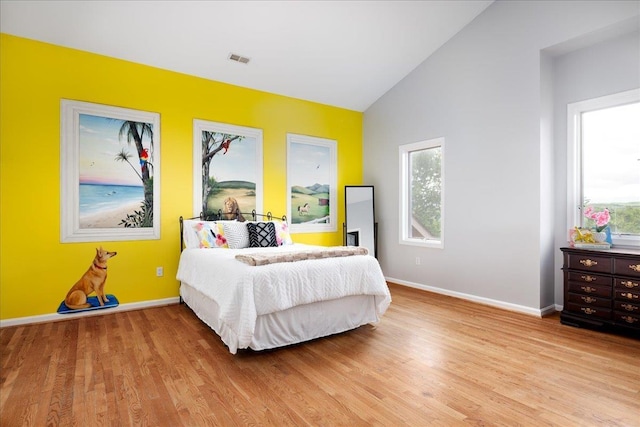 bedroom with lofted ceiling and light wood-type flooring