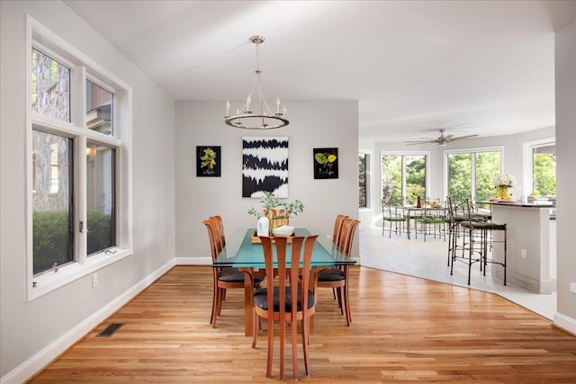 dining space featuring a notable chandelier, a wealth of natural light, and light hardwood / wood-style floors