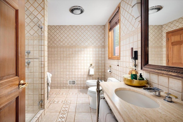 bathroom featuring sink, tile walls, tile patterned flooring, toilet, and a bidet