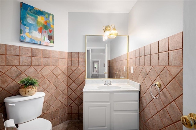 bathroom featuring vanity, toilet, and tile walls