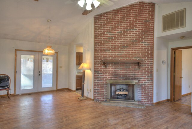 unfurnished living room with french doors, a fireplace, high vaulted ceiling, and light hardwood / wood-style flooring